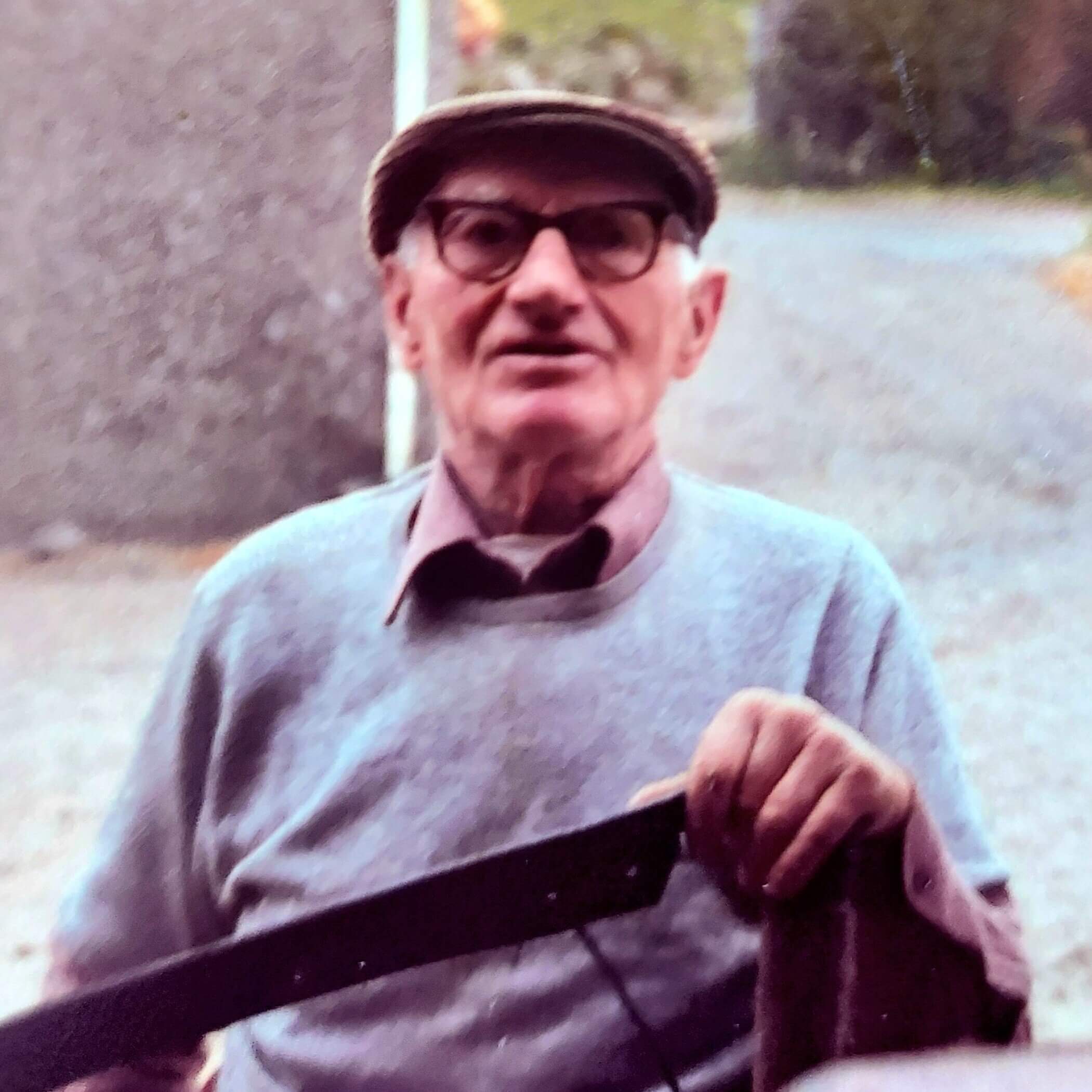 Joe McCaughan from The Hollow, Glenshesk, holding a scythe, 1970's